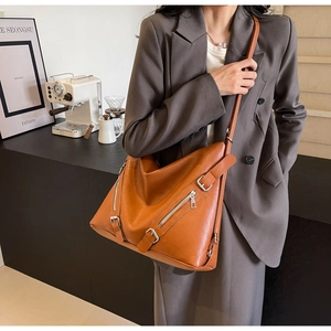 Detail shot of the brown PU leather tote with adjustable buckle and side zipper accents