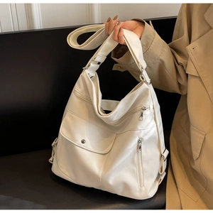 Detailed view of white large capacity tote bag with multiple zippers and silver hardware