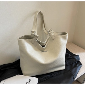 Close-up of cream white tote bag featuring pebble grain leather texture and silver hardware