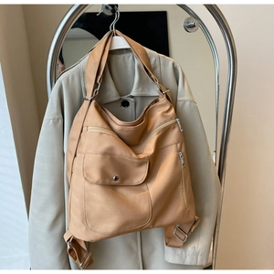 Detail of light coffee canvas hobo bag with multiple zippers and adjustable strap