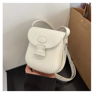 Close-up of white crossbody bag featuring vertical pleated texture and fashion label