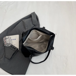 Internal view of black leather tote bag showing large capacity and zippered lining pocket
