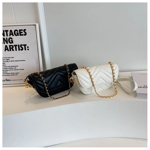 Close-up of chevron quilted leather shoulder bags in black and ivory with gold chains
