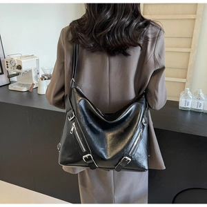 Detail of black large hobo bag with pebbled leather texture and silver zipper accents
