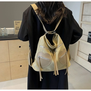 Detail of vintage corduroy backpack with heart pockets and decorative long tassels