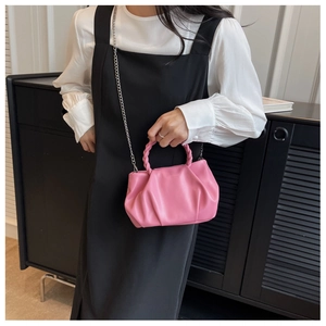 Detailed shot of pink pleated cloud bag with woven handle and silver chain strap