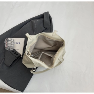 Interior view of off-white lychee pattern tote bag with large main zip pocket and card slot