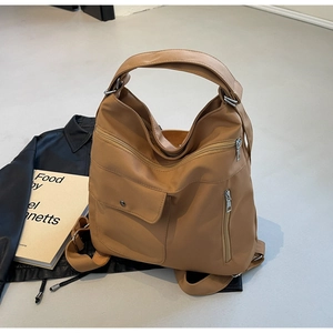 Detail of camel nylon shoulder bag featuring multiple zipper pockets and functional compartments