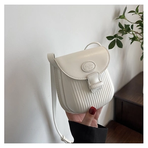 Detail of white PU leather crossbody bag with vertical pleated texture and metal logo