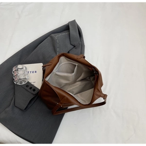 Detail view of large brown tote bag interior featuring gray lining and zipper pocket