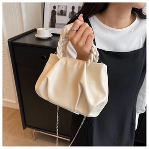 Detail of off-white ruched cloud bag with woven handle and silver chain strap