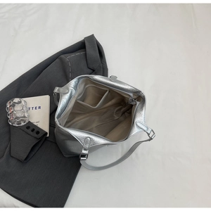 Top view of silver metallic tote bag interior showing multi-pocket design and PU leather
