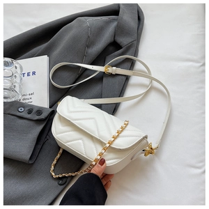Detail of white V-quilted faux leather shoulder bag with golden chain strap and flap