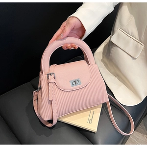 Detailed view of pink quilted handbag with silver swivel lock and thin adjustable strap
