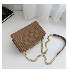 Detailed close-up of brown quilted faux leather square bag with gold metal chain strap