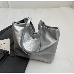 Detail view of silver tote bag with lychee texture and minimalist metal bar accent