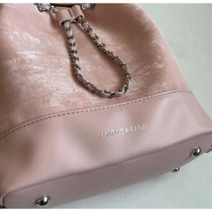 Close-up of pink bucket bag showing suede stitching detail and silver brand logo