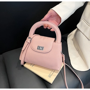 Close-up of pink leather handbag featuring fine vertical textures and silver swivel lock