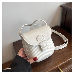 Close-up of white mini crossbody bag featuring vertical pleated texture and metal nameplate