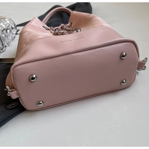 Close-up of pink bucket bag base with silver metal feet and mixed texture fabric