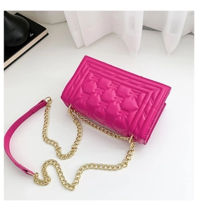 Detailed 45-degree macro view of quilted flamingo pink bag with gold chain strap