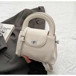 Detail of white lychee texture bag with vertical pleats and silver metal twist lock