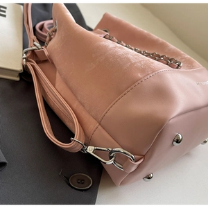 Close-up of pink bucket bag with suede and PU leather stitching and silver metal chain