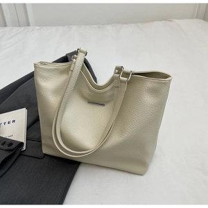Detail of soft cream white leather tote bag with silver bar and wide straps for work