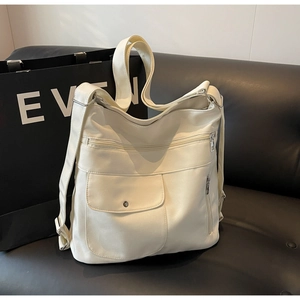 Detail view of large cream PU tote bag with multiple zip pockets and adjustable strap