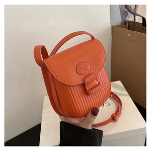 Detail of orange crossbody bag featuring vertical pleated texture and fashion bags embossing