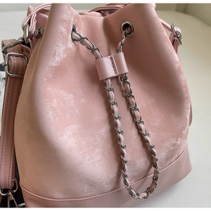 Detail view of the pink matte leather bucket bag with silver metal chain drawstring closure