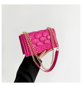 Detail of fuchsia quilted handbag with gold chain strap and glossy bubble texture