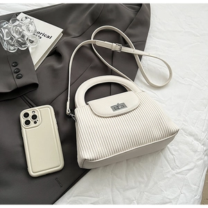 Macro detail of white quilted texture small square bag with silver metal buckle