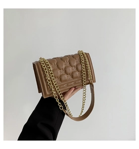 Detailed view of brown quilted chain shoulder bag with classic diamond stitching and gold strap