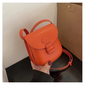 Close-up of orange textured mini crossbody bag with Fashion Bag logo and handle