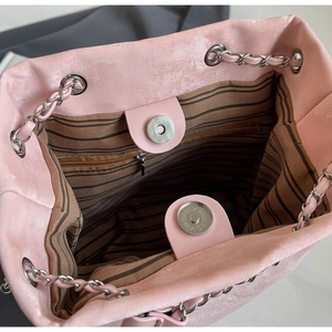 Detail shot of pink bucket bag featuring magnetic closure and striped fabric lining
