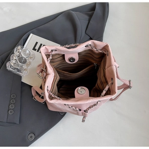 Detailed interior of pink bucket bag showing striped lining and magnetic snap closure