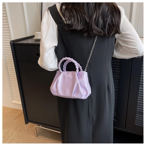 Detail of light purple pleated cloud bag with woven handle and silver chain strap