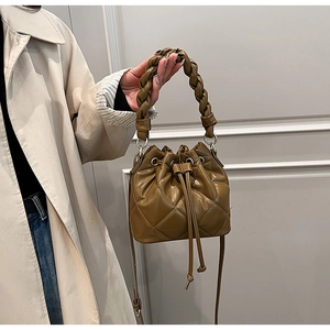 Dettaglio della borsa a secchiello in pelle trapuntata con manico intrecciato e coulisse