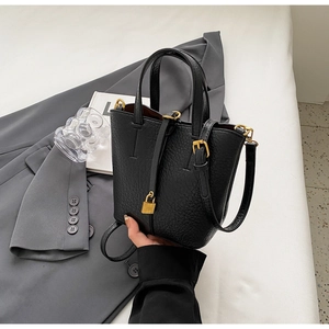Detail of black lychee leather bucket bag with gold hardware and iconic padlock detail