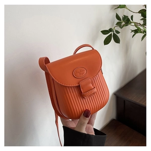 Detail view of an orange PU leather crossbody bag featuring vertical pleated texture