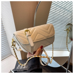 Close-up of white quilted leather crossbody bag featuring gold chain and buckle details