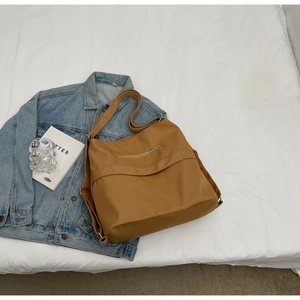 Detail view of brown large tote bag showing durable fabric and rear zipper pocket