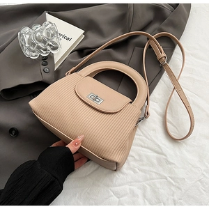Detail shot of milk tea shoulder bag with vertical pleats and silver square metal swivel lock