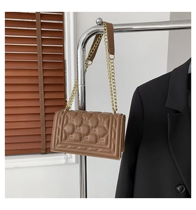 Detailed view of brown quilted PU leather handbag with elegant gold chain shoulder strap