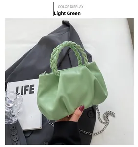 Detail of freshwater green pleated cloud bag with woven handle and silver chain