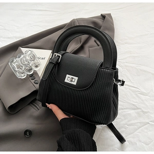 Detail of black handbag showing pleated texture contrast and silver square rotating lock