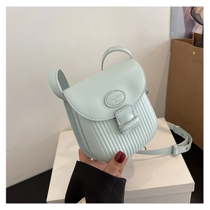 Detail of mint green crossbody bag with vertical pleated texture and adjustable strap