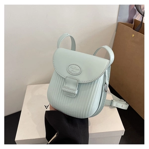 Detail shot of mint green crossbody bag with vertical ribbed texture and fashion label