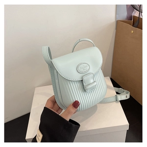 Detail of light mint green PU leather crossbody bag featuring vertical embossed texture